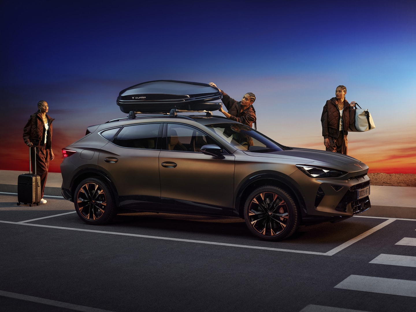 CUPRA Formentor SUV with roof box and travel accessories at sunset, featuring stylish passengers and premium design for adventure and road trips.
