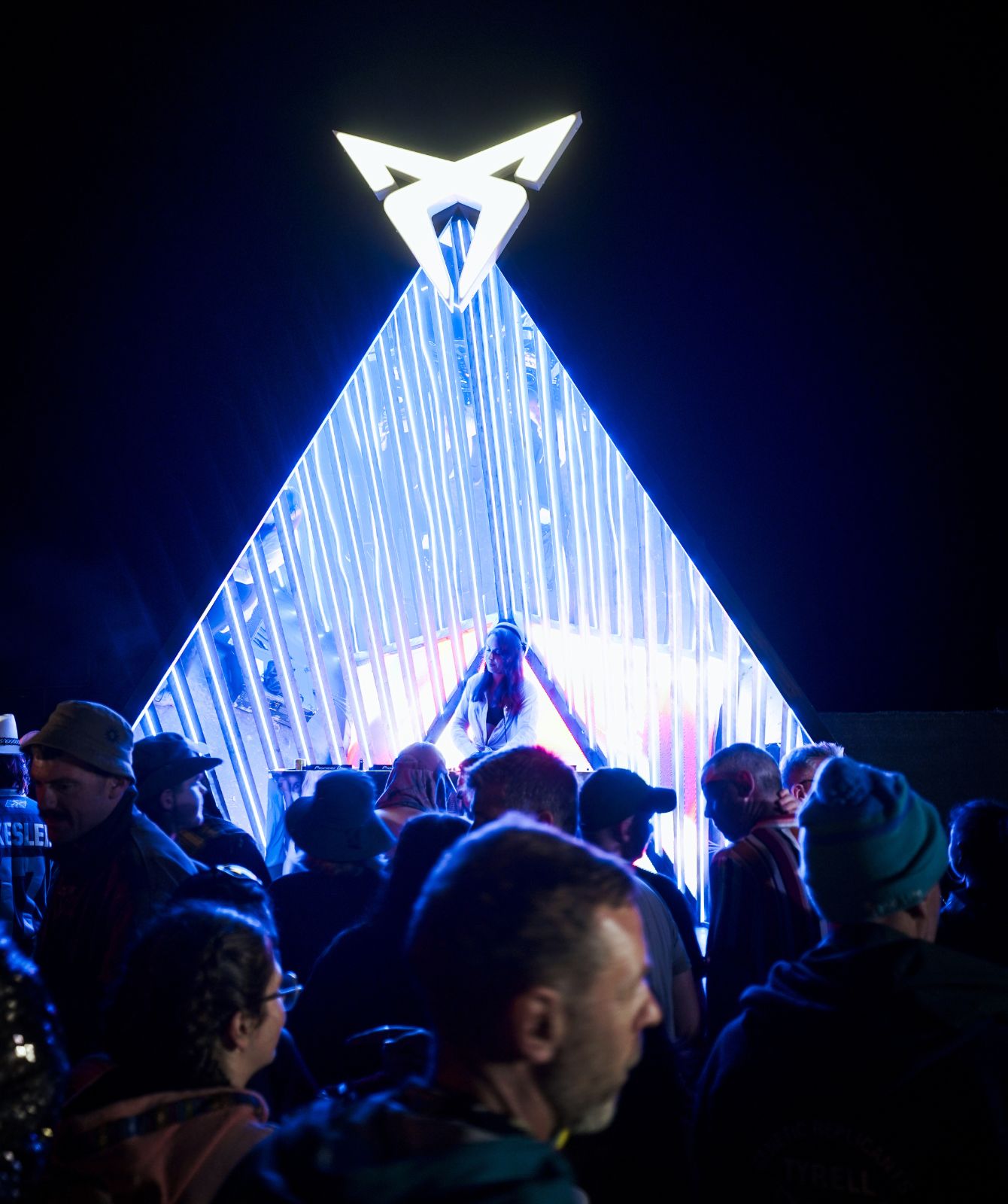 CUPRA Pulse at night during the Beyond the Pale festival, featuring vibrant lights and a lively atmosphere.