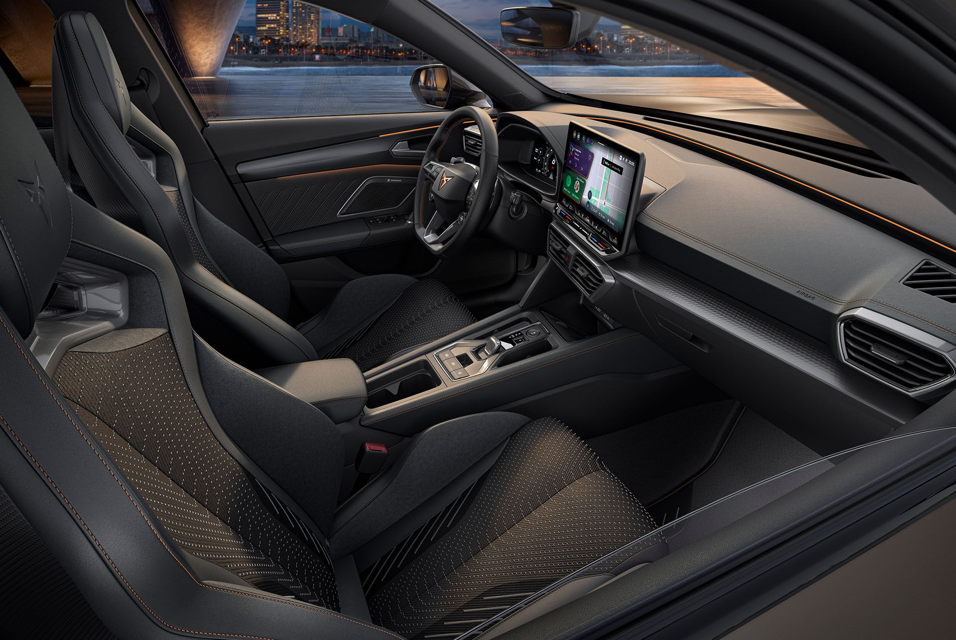 Interior view of the new CUPRA Formentor’s cockpit. The cabin features black bucket seats, copper accents and stitching, the infotainment system and a steering wheel with the CUPRA logo.