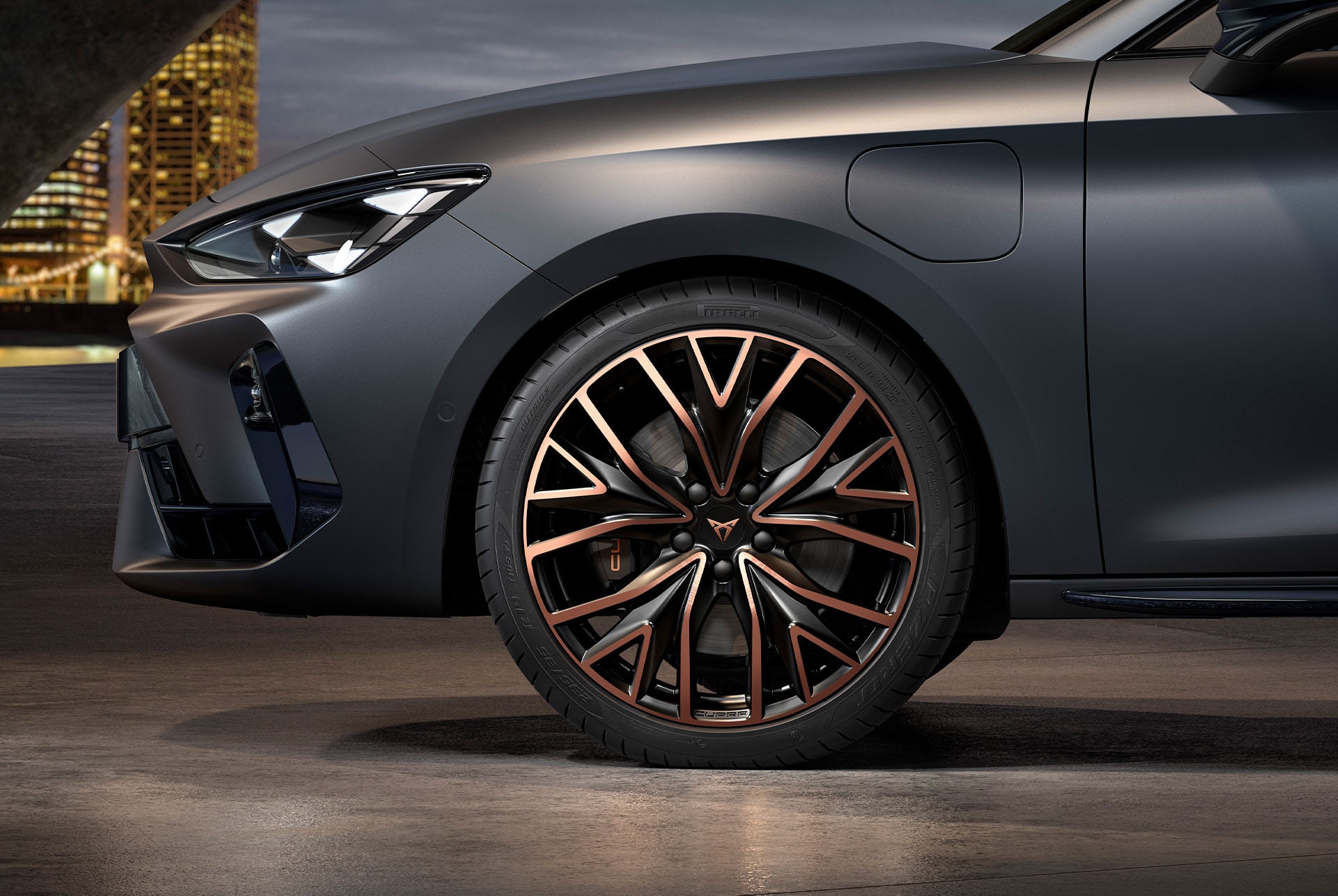 front side view of left mistral copper forged wheels in copper and black for the new cupra leon sportstourer 2025, tyres, signature headlights and grey body