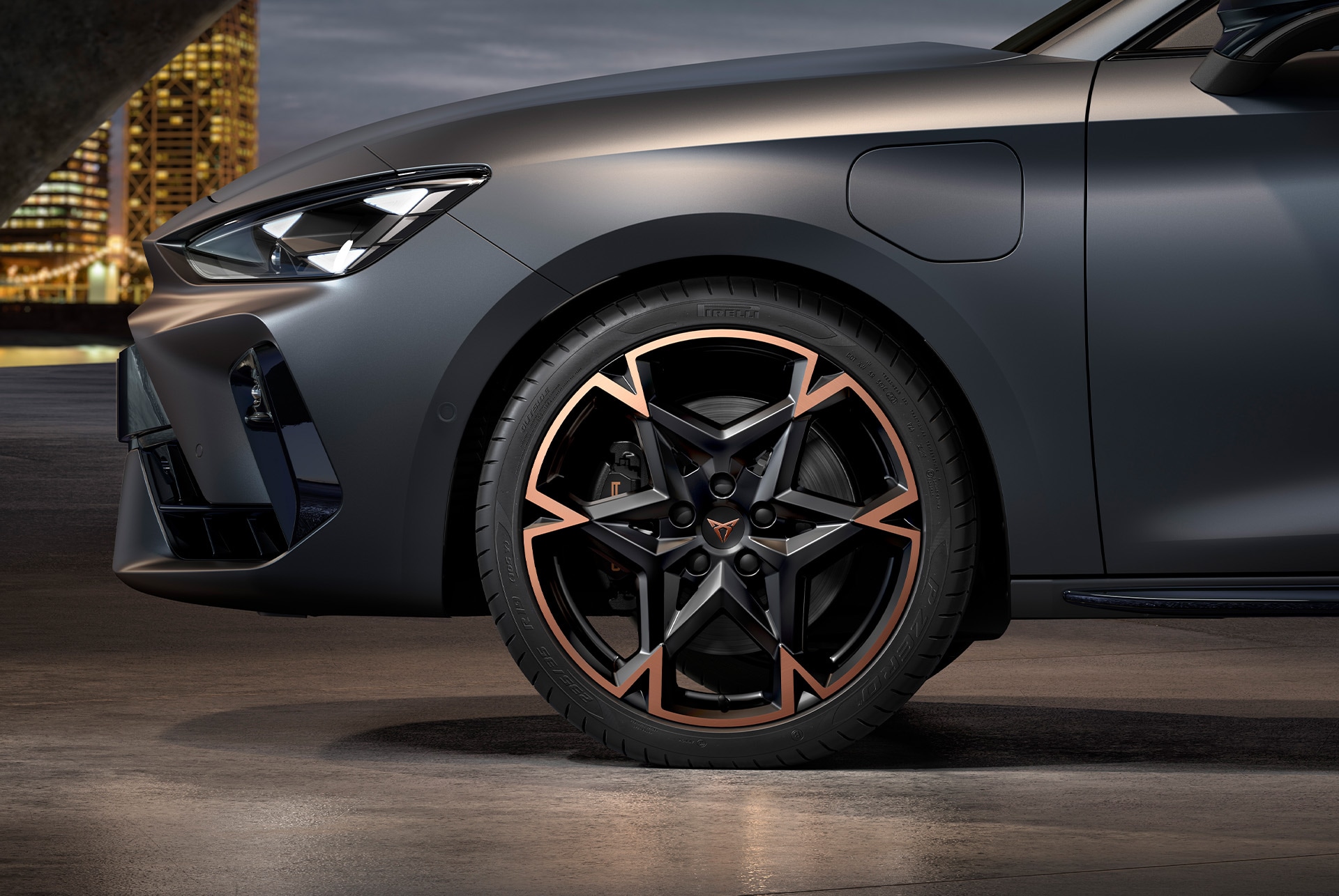 front side view of left machined alloy wheel in black and copper for the new cupra leon spotstourer 2025, tyres, signature headlights and grey body
