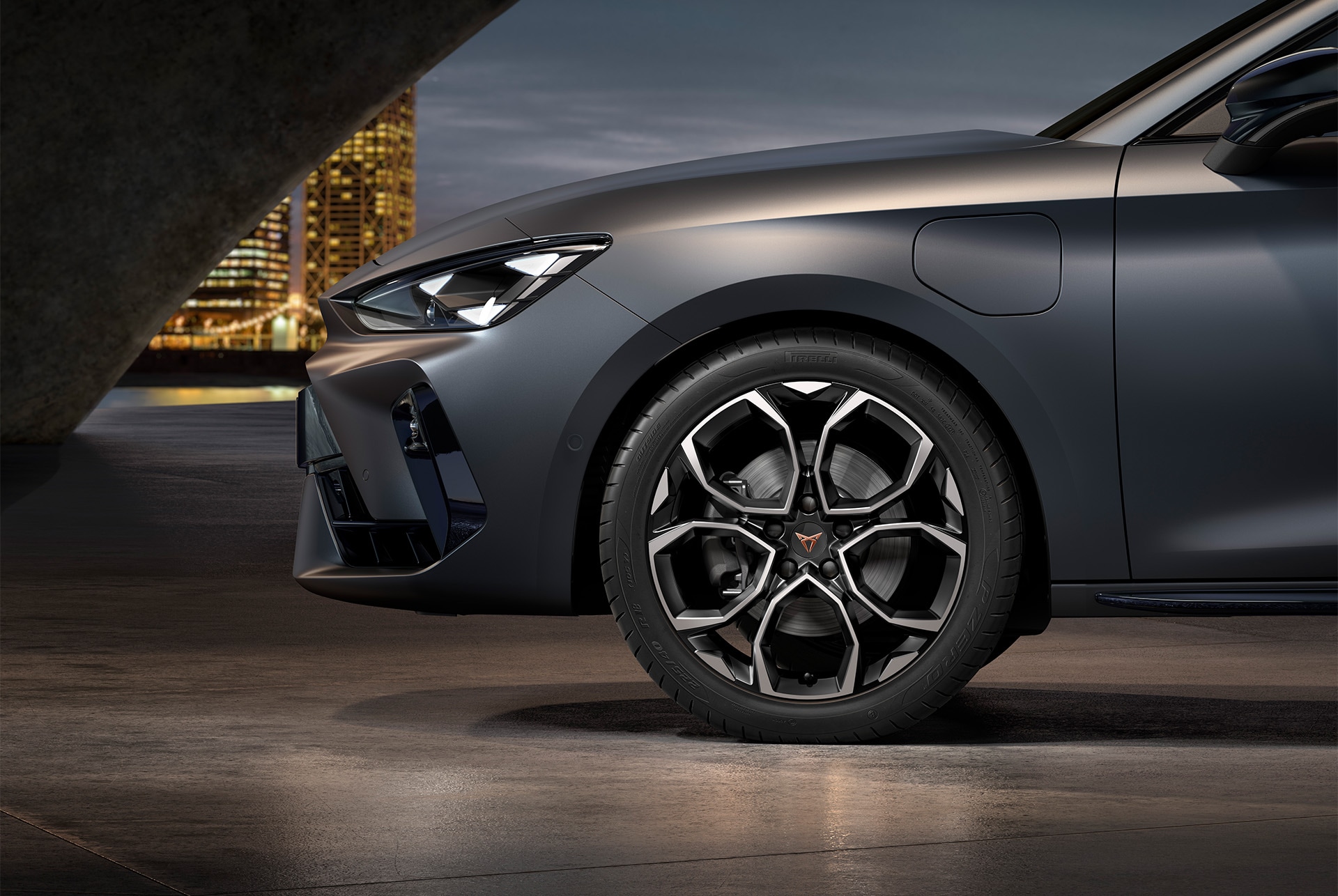 front side view of left machined silver and black windstorm alloy wheel for the new Cupra Leon 2025, tyres, signature headlights and grey body.