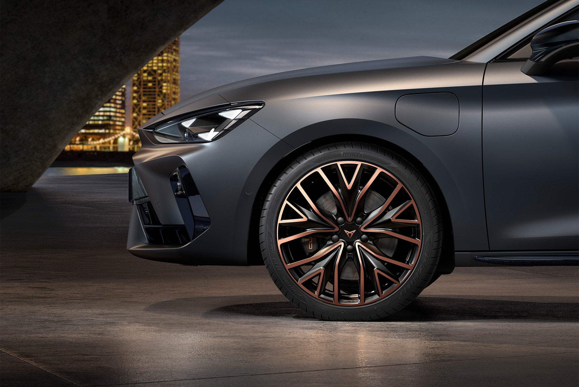 front side view of left mistral copper forged wheels in copper and black for the new Cupra Leon 2025, tyres, signature headlights and grey body.