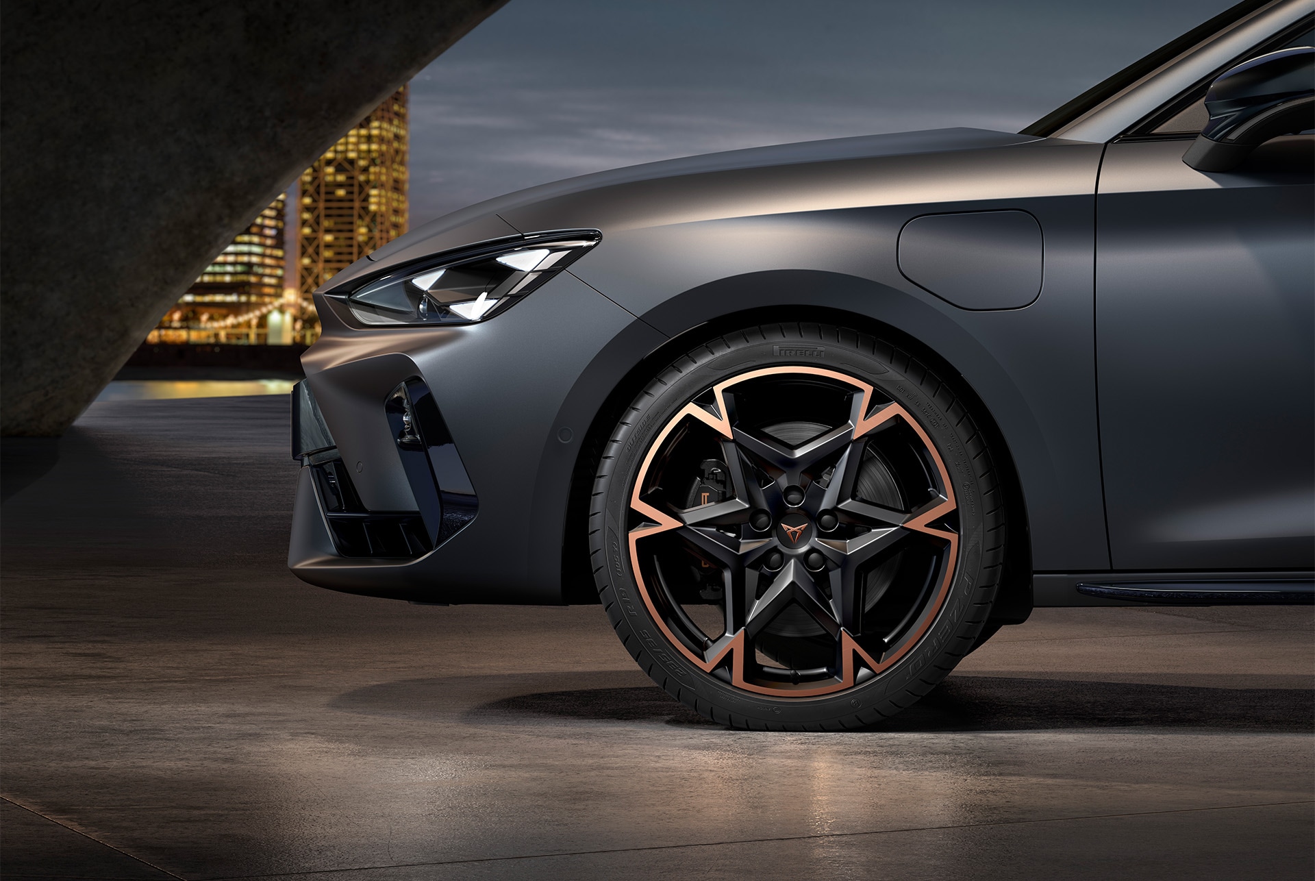 front side view of left machined alloy wheel in black and copper for the new Cupra Leon 2025, tyres, signature headlights and grey matt body.