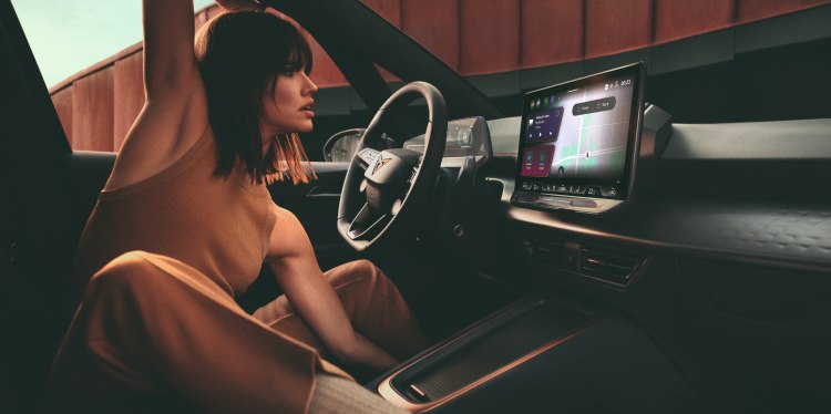 A woman sitting comfortably in a cupra car interior, interacting with the infotainment system, highlighting modern design and control with personal contact plan (pcp).