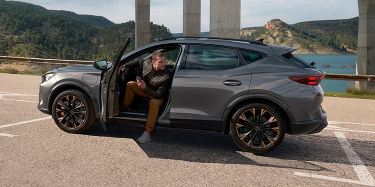cupra formentor and man wating to received roadside assistance for electric and hybrid cars